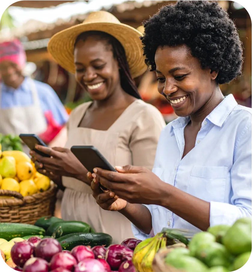 Two African women in a market using WhatsApp banking powered by cGrate
